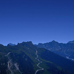 Obraz premium Serene Mountain Road Under Clear Blue Sky