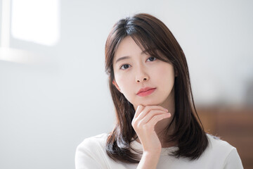 カメラ目線で真剣で真面目な表情で考える若い女性
