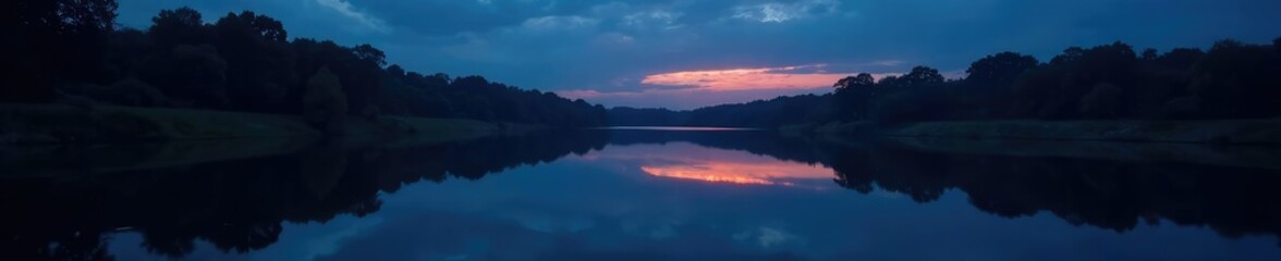 Fototapeta premium Dark skies reflect in the mirror-like surface of a slow-moving river at night, darkness, peaceful, calm