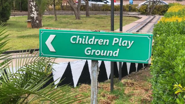 Children play ground sign indicate left on green plastic plastic