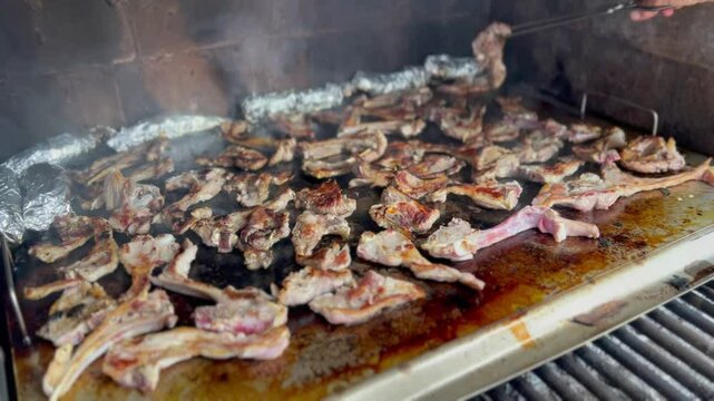 Lamb chops cooking on a smoking grill. Outdoor barbecue.