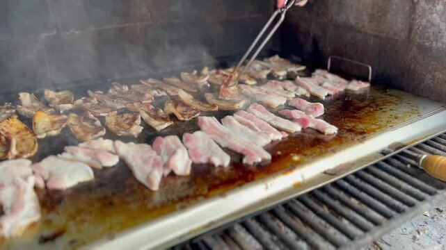 Barbeque with raw pancetta. Smoking outdoor grill. Copy space.
