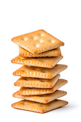 Stacked pile of crispy saltine crackers, isolated on white background