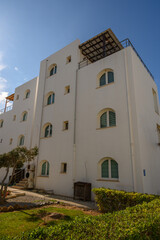 Elegant coastal building blending white architecture and bright blue skies in a serene seaside location