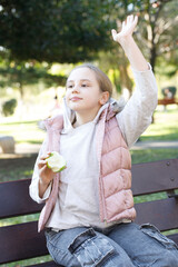Fototapeta premium Friendly child girl walking in city park outdoors. Healthy playful kid portrait