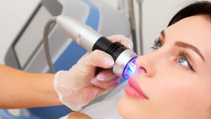 Close-up of a young woman undergoing fractionated radiofrequency treatment for skin rejuvenation at a medical center. Ideal for demonstrating advanced cosmetic procedures. 