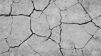 Obraz premium A close-up of cracked concrete, revealing a rough, weathered surface with distinct fissures and textures.