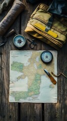 Aerial view of a map with compass and gear on a wooden table, perfect for adventure planning.