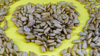 Heart-shaped arrangement of seeds on a bright yellow background