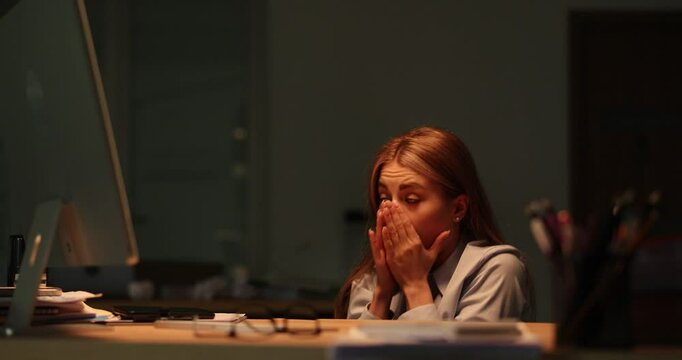 Frightened woman secretary crouches near office desk. Scared office worker hears rumbles of thunder and hides under table at thunderstorm. Slow motion