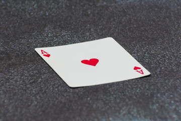Single Ace of Hearts playing card lying on a surface. A classic symbol of luck, power, and high-stakes card games.