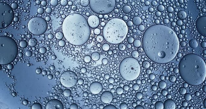 Slow motion macro of floating micro particles molecules in liquid are analyzed with microscope by chemist during innovative new medical research and analysis in scientific pharmaceutical laboratory.