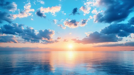 Fototapeta premium A serene sunrise over the calm ocean horizon with fluffy clouds