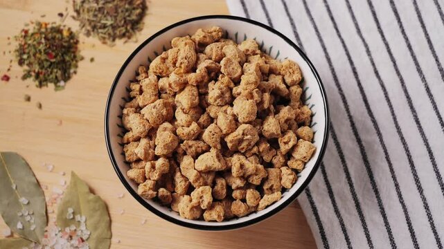 Dried soy meat pieces in a bowl with species. Textured vegetable protein. Healthy eating. Vegan food. High quality 4k footage