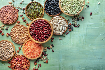 Various legumes, overhead flat lay shot. Many different pulses, an assortment. Plant-based vegan protein, top shot on a blue background