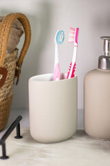 Hygiene items like toothbrushes and liquid hand soap on a marble tray, complemented by greenery in a light, airy interior.