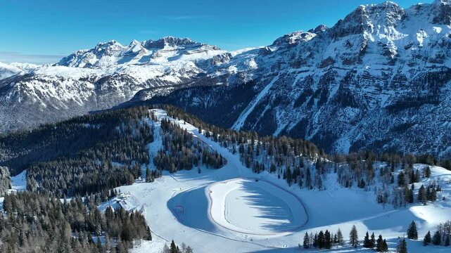 Aerial drone view of sunny winter in dolomites, alps. Pinzolo village and a ski resort in Italy. Dolomites Brenta, Adamello park and Presanella moutain, Doss del Sabion skiarea trentino Italy.