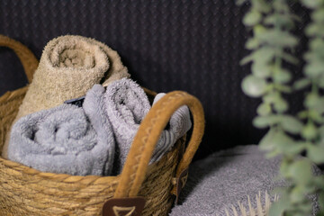 A basket with towels in a dark interior,  bathroom.