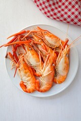 Boiled prawn in white ceramic plate on white background , top view food table with free copy space