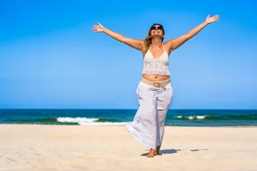  Beautiful middle-aged woman enjoying holidays on white sandy beach on sunny summer day. Happiness and freedom. Front view © Jacek Chabraszewski