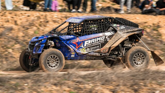 Madrid, Spain; 02-15-2025: Can-Am Maverick X3 buggy speeds on a dirt track, its agile maneuvering and dust trail highlighting the adventurous spirit of off-road racing