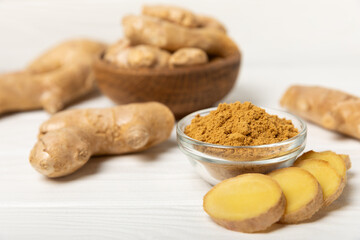 Fresh ginger on wooden background. Dry ginger. Sliced ​​ginger with honey and lemon. Ginger root. Traditional alternative medicine, healing tea for immunity. Seasoning and spices concept. Copy space.