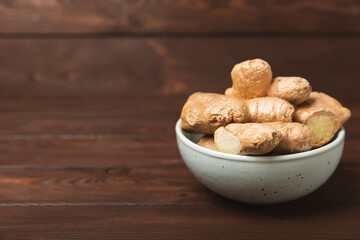 Fresh ginger on wooden background. Dry ginger. Sliced ​​ginger with honey and lemon. Ginger root. Traditional alternative medicine, healing tea for immunity. Seasoning and spices concept. Copy space.