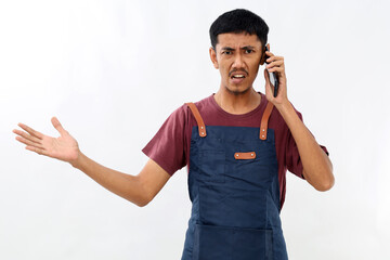 Young indignant confused asian man barista bartender barman employee in blue apron red t-shirt work...
