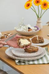 Woman smearing butter on Hot Cross Buns. Happy Easter