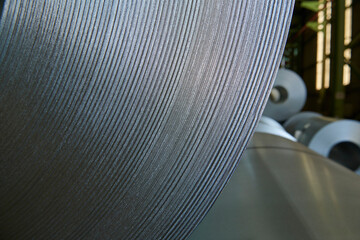 Galvanized steel coil detail and factory background.