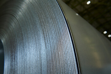 Galvanized steel coil detail and factory background.