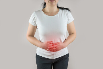 woman in white t-shirt suffers from stomach pain