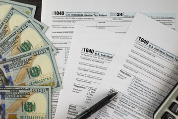 Tax form 1040 on dark wooden background, financial document.