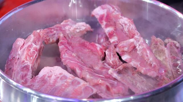 Boiling pork backbones in a large pot