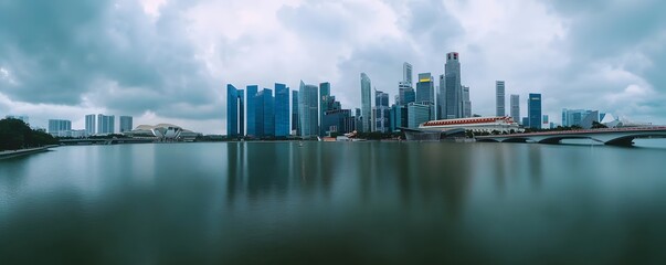 Naklejka premium Singapore skyline reflects upon the water under a cloudy sky