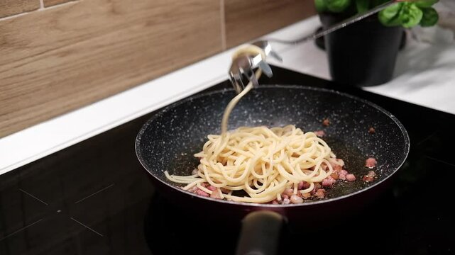 chef roasts cubes of bacon or Italian pork guanciale or pancetta in a pan for Italian pasta carbonara , A woman cooking Italian spaghetti carbonara pasta 
