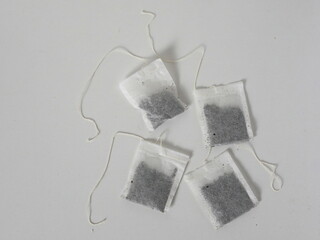 four tea bags on a white table