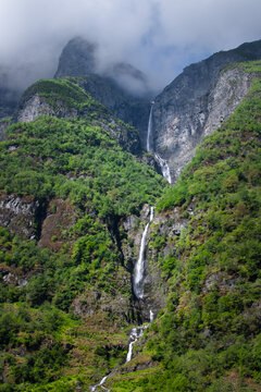 A waterfall flowing down the steep mountain wall of a Norwegian fjord