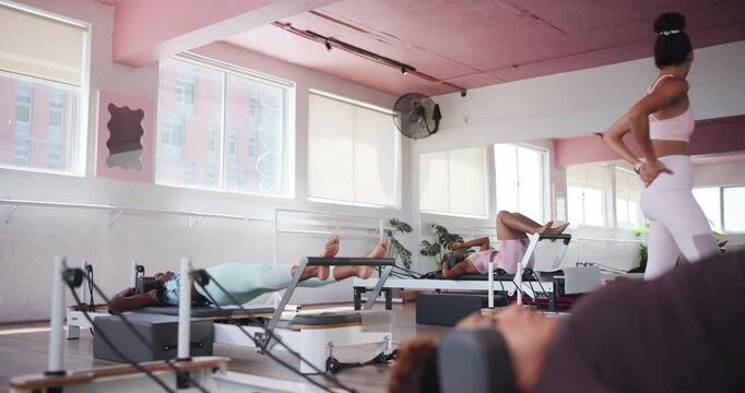 Pilates instructor, reformer equipment or woman in workout for fitness, body balance or group class. People, training machine or core strength exercise in studio for resistance, health or flexibility