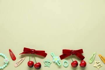 Different hair accessories on light green background, flat lay. Space for text