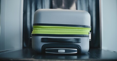 Security Checkpoint in Modern Airport Terminal: Suitcase of Passenger Moving on Conveyor Belt from...