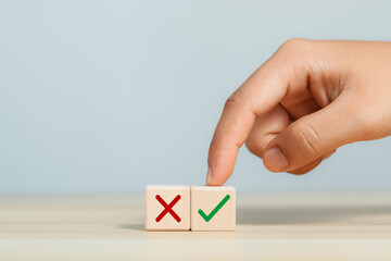 Wooden blocks thinking and deciding between right and wrong symbols, voting decisions, yes or no...