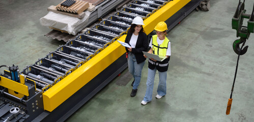 Technician maintains and inspects metal sheets in a metal cheese plant with computers and radio...