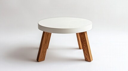 A small, round coffee table with a matte white top and natural wood legs, perfectly isolated on a bright white background.