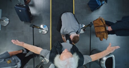 Security Checkpoint in Airport Terminal: Diverse People Passing Through X-ray Metal Detector...