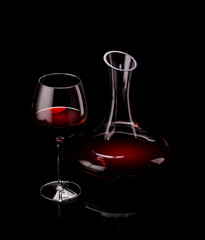 Elegant presentation of red wine in a glass and a decanter against a dark background
