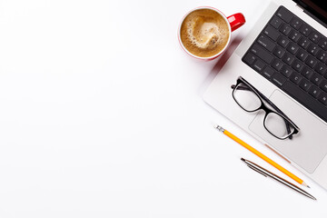 A clean and minimal desk setup featuring a laptop and a coffee cup