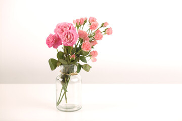 Obraz premium Beautiful bunch of fresh pink roses in full bloom against white background. Bouquet of flowers. Copy space for text. Valentine's day or Mother's day card.
