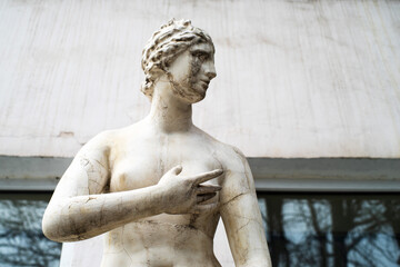 Damaged copy of Venus plaster sculpture on the street in front of the building