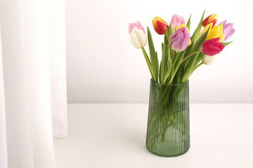 White spring tulips in a vase on a white table. Mock up for displaying works